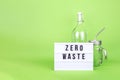 Reusable glass bottle and jar with metal straw and cinema lightbox on the light green drop Royalty Free Stock Photo