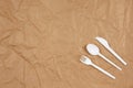 Reusable recyclable white fork, spoon, knife made from corn starch on brown crumpled craft paper, copy space. Eco, zero waste, Royalty Free Stock Photo