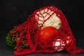 Reusable red string bag with organic vegetables from the farm on a black background. Zero waste concept. Closeup Royalty Free Stock Photo