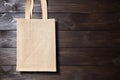 Reusable shopping bag, natural textile fiber, blank eco hessian or jute sack on brown wooden background Royalty Free Stock Photo