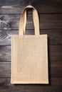 Reusable shopping bag, natural textile fiber, eco hessian or jute sack on brown wooden background Royalty Free Stock Photo