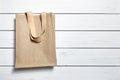 Reusable shopping bag, natural textile fiber, eco hessian or jute sack on white wooden background Royalty Free Stock Photo