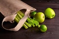 Reusable shopping jute bag with fresh fruits and greens on wooden background Royalty Free Stock Photo