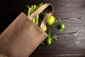 Reusable shopping jute bag with fresh fruits and greens on wooden background Royalty Free Stock Photo