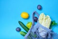 shopping String bag, open netted bag with fresh apples. blue Mesh shopping bag with fruits on green shadow background.