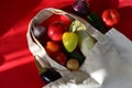 Reusable shopping textile bag full of groceries, fresh fruits and vegetables purchased from the store on red background Royalty Free Stock Photo