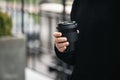 Reusable stylish bamboo black cup in the hands of a man, close-up.