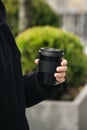 Reusable stylish bamboo black cup in the hands of a man, close-up.