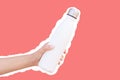 Reusable thermo water bottle in hand, isolated with white contour on red.