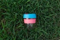 Reusable travel plastic keep cup on grass background. glass takeaway mug. take your coffee to go. eco friendly and zero