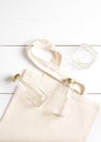 Reusable woven bag and glass bottles and jars, lie on a white background