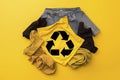 Reuse, reduce, recycle concept background. Recycle symbol made from old clothing on yellow background Royalty Free Stock Photo