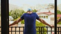 Revealing shot of man relaxing on balcony