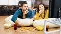 Revealing shot of young couple watching tv