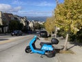 Revel electric moped parked on on the steep Divisadero street with San Francisco Bay in background - San Francisco, California, Royalty Free Stock Photo