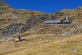 A lonely hiker arriving in view of the mountain hut