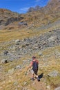 A lonely hiker on the path in view of the mountain hut