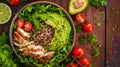 Healthy salad bowl with quinoa, tomatoes, chicken, avocado, lime and mixed greens, lettuce, parsley on wooden background top view
