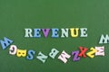 REVENUE word on green background composed from colorful abc alphabet block wooden letters, copy space for ad text. Learning Royalty Free Stock Photo