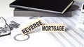 REVERSE MORTGAGE - text on a wooden block with chart and notebook Royalty Free Stock Photo