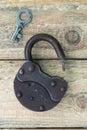 Reverse side opened old rusty lock with key lying near. Copy space. Looking for problem solution concept in steampunk Royalty Free Stock Photo