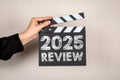 2025 Review. Film Clapperboard Held Against a Neutral Background Royalty Free Stock Photo