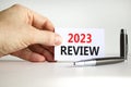 2023 Review symbol. White paper with words 2023 Review. Businessman hand. Metallic pen. Beautiful white table white background.