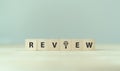 Review text on wooden cube blocks. Review evaluation time for review inspection assessment auditing. Royalty Free Stock Photo