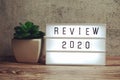 Review 2020 word in light box on wooden background