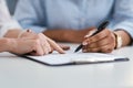 Revising a few business policies. Closeup shot of two unrecognisable businesswomen going through paperwork together in