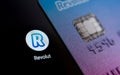 Revolut bank card on the smartphone screen next to app icon. Revolut Ltd is a UK financial technology company that offers banking Royalty Free Stock Photo