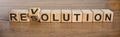 Revolution or resolution words on wooden cubes in brown background. Concept Royalty Free Stock Photo