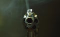 Revolver gun muzzle with smoke floating in the air after shoot on black background Royalty Free Stock Photo