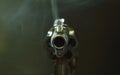 Revolver gun muzzle with smoke floating in the air after shoot on black background