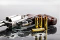 Revolver hand gun and bullets with bullet holes in glass over black , Can be used as a background Royalty Free Stock Photo