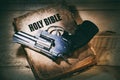 Revolver on an old bible on a wooden table