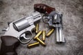 Revolver pistol hand guns with bullets on cement texture background