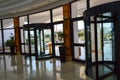 Revolving glass door shopping center building three-door structure anchored rotating on a vertical axis and orange sign wet floor Royalty Free Stock Photo