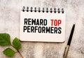 Reward top performers text memo written on a white background with pencils