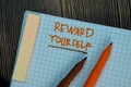 Reward Yourself write on a book isolated on Wooden Table. Motivation or Insipiration Concept Royalty Free Stock Photo