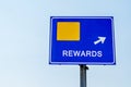 Rewards Blue Road Sign Against Sky Royalty Free Stock Photo