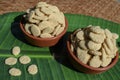Rewri or Sesame seed sugar jaggery, Indian Sankranti festical food item. Rewri gajak served in earthen pot bowl on banana leaf