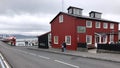 Reykjavik, Iceland - July 2, 2018: View of a Caruso restaurant by a marina, along with people, boats and the mountains in the