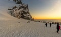 Reynisfjara beach completely covered in snow at sunset and the basalt formations illuminated by the last rays of the sun from the