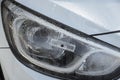 An RFID tag sticker on the headlight of a pearl white car Royalty Free Stock Photo