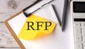RFP word on a yellow sticky with calculator, pen and clipboard Royalty Free Stock Photo