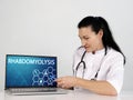 RHABDOMYOLYSIS inscription on the screen. Close up Doctor hands holding black laptop