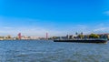 A Rhine Barge on the Nieuwe Maas river in Rotterdam with the red cable stayed Willems Bridge in the background