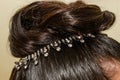 A rhinestone embellishment in the hairstyle of a black-haired bride on her wedding day.