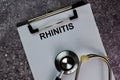 Rhinitis write on a paperwork and stethoscope isolated on office desk